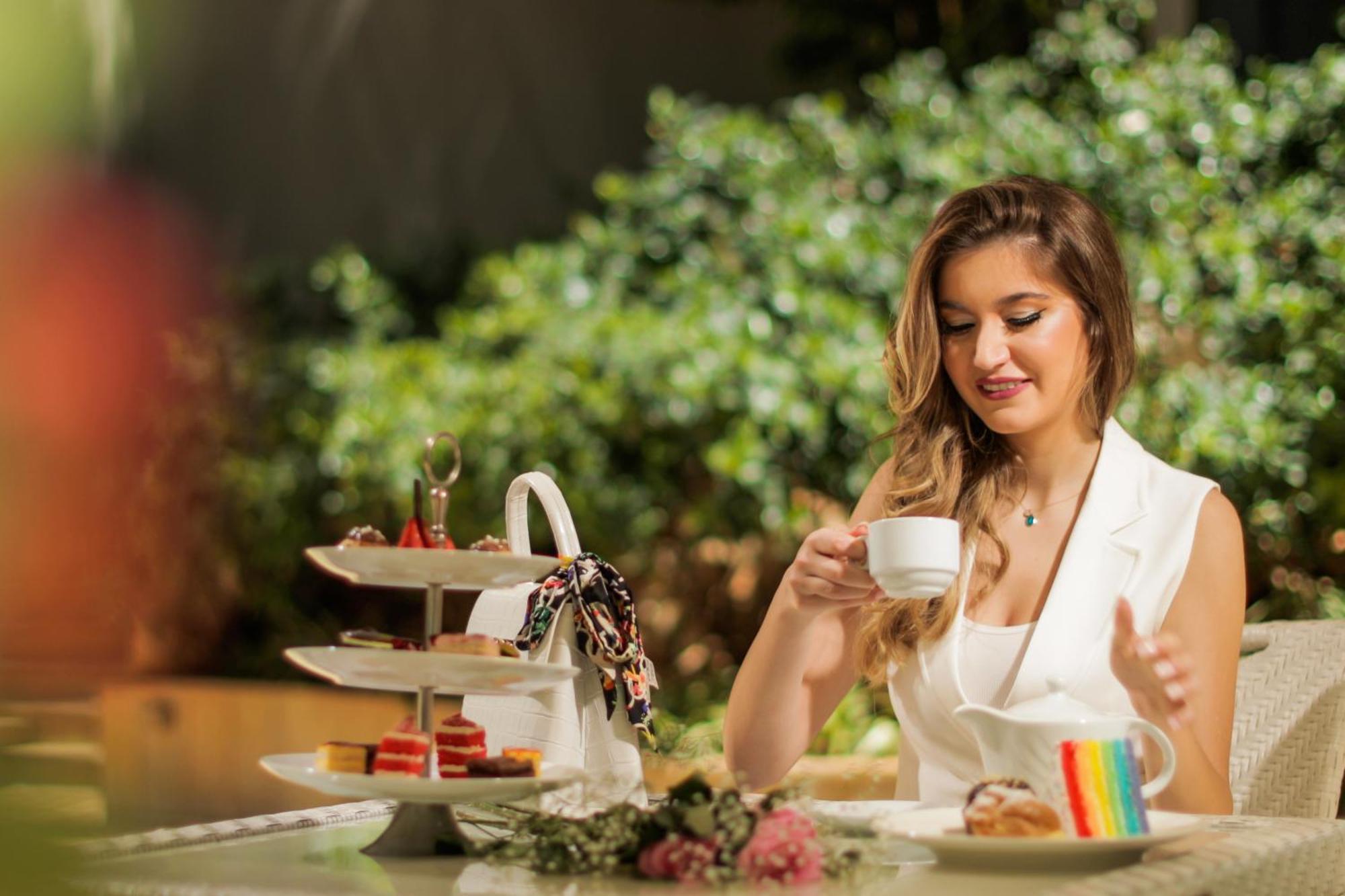 Gefinor Rotana - Beirut Hotel Bagian luar foto A woman drinking tea