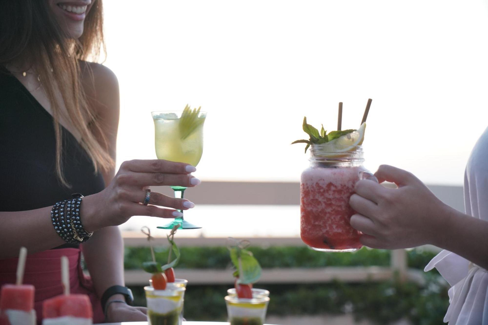 Gefinor Rotana - Beirut Hotel Bagian luar foto Two people holding cocktails